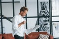 Reads newspaper. Caucasian young guy in elegant white shirt indoors at home Royalty Free Stock Photo