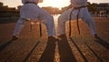 Ready for battle. Two sportspeople facing off and practicing their karate while wearing gi.