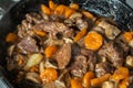 Ready of Beef Burgeoning beef dish in a frying pan. meat, carrots and onions and mushrooms. Appetizing sauce. Slow food Royalty Free Stock Photo