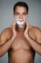 Ready for a close shave. Studio portrait of a handsome mature man applying shaving cream to his face.