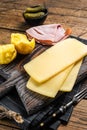 Ready for cooking Raclette Swiss cheese slices with boiled potato and ham. Wooden background. Top view
