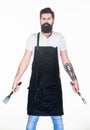 Ready for cooking and serving food. Bearded man with fork and spatula in hands. Kitchen tools for cooking barbecue Royalty Free Stock Photo