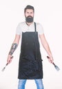 Ready for cooking and serving food. Bearded man with fork and spatula in hands. Kitchen tools for cooking barbecue Royalty Free Stock Photo