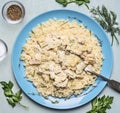 Ready couscous with turkey on a blue plate with a spoonful of salt, spices and herbs wooden rustic background close up top view