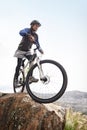 Ready for the down hill. A young man riding a mountain bike with a scenic view in the background. Royalty Free Stock Photo