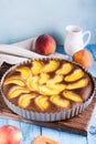 Ready fresh peach pie in a baking dish on the table. Homemade dessert. Vertical view