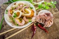 Ready fresh squid rings and tentacles of an octopus with stewed potatoes greens in rustic. Close-up