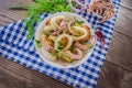 Ready fresh squid rings and tentacles of an octopus with stewed potatoes greens in rustic. Top view. Close-up