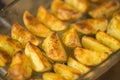 Ready golden baked potato slices in glass dish after oven