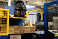 Ready-made cardboard boxes are moved in stacks along an automated packaging line. The strapping machine packs the stacks with
