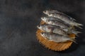 Dried dry silver bream fish, laid out against a dark background, close-up