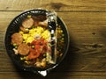 Ready made Spanish paella in a black plastic dish for microwave on a wooden table. Premium quality meal for take away or on the go Royalty Free Stock Photo