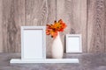 Ready Mock up. Two empty photo frames on a stand and a vase with orange maple leaves stand on the table Royalty Free Stock Photo