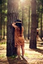 Ready or not, here I come. little girls playing hide and go seek in the woods while dressed as red indians. Royalty Free Stock Photo