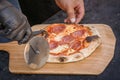 Ready pizza lies on the table for cutting into pieces