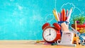 Ready for school, Back to school concept. Alarm clock with pencils and school accessory on blue chalkboard background Royalty Free Stock Photo