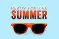 Ready for the Summer orange text message and orange sunglasses isolated in a blue background.