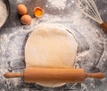 Ready to be baked dough. Top view of board, rolling pin and flour and dough