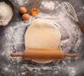 Ready to be baked dough. Top view of board, rolling pin and flour and dough