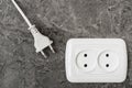 White power plug and electric socket on stone wall Royalty Free Stock Photo
