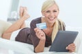 Ready to do some shopping. Portrait of a beautiful woman doing some online shopping at home using her digital tablet. Royalty Free Stock Photo