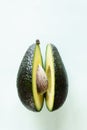 Ready to eat avocado cut into two halves, isolated on light green background Royalty Free Stock Photo