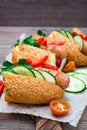 Ready-to-eat hot dogs from fried sausages, sesame buns and fresh vegetables on a cutting board Royalty Free Stock Photo