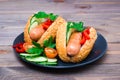 Ready-to-eat hot dogs from fried sausages, sesame buns and fresh vegetables on a plate Royalty Free Stock Photo