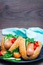 Ready-to-eat hot dogs from fried sausages, sesame buns and fresh vegetables on a plate Royalty Free Stock Photo