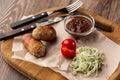 Ready-to-eat pigs sausages wrapped in bacon on wooden board. Fried savory sausages wrapped in bacon served with onion Royalty Free Stock Photo