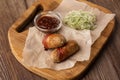 Ready-to-eat pigs sausages wrapped in bacon on wooden board. Fried savory sausages wrapped in bacon served with onion Royalty Free Stock Photo