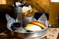 Ready-to-eat sandwich with a fried egg, on a plate with fries Royalty Free Stock Photo