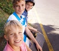 Ready to go downhill. Portrait of three young brothers enjoying a day outside skateboarding. Royalty Free Stock Photo