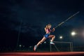 Female pole vaulter training at the stadium in the evening