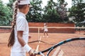 Ready to play. Cropped side view focused on sporty child with beautiful tennis player on blurred background.Young woman preparing Royalty Free Stock Photo