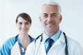 Ready to save lives. Portrait of a young nurse and a mature doctor smiling at the camera. Royalty Free Stock Photo