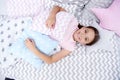 Ready to sleep. Girl smiling happy child lay on bed with star shaped pillows and cute plaid in her bedroom. Bedclothes