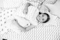 Ready to sleep. Girl smiling happy child lay on bed with star shaped pillows and cute plaid in her bedroom. Bedclothes Royalty Free Stock Photo