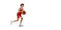 Full-length portrait of young boy, basketball player in motion, training isolated over white studio background. Flyer Royalty Free Stock Photo