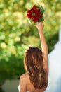 Ready to toss the bouquet. Rearview shot of a young bride about to toss her bouquet over her shoulder.