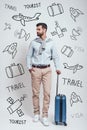 Ready to travel. Full length of handsome bearded young man waiting with suitcase while standing against grey background Royalty Free Stock Photo