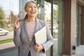 Ready to work. Beautiful and happy mature business woman holding laptop and smiling while standing near office building Royalty Free Stock Photo