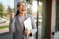 Ready to work. Beautiful and happy mature business woman holding laptop and smiling while standing near office building Royalty Free Stock Photo