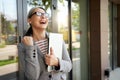 Ready to work. Beautiful and happy mature business woman holding laptop and smiling while standing near office building Royalty Free Stock Photo