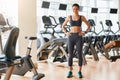 Ready for workout Full legth of deautiful and sporty woman in sportswear is keeping hands on her hips and looking at Royalty Free Stock Photo