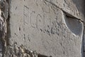 Real ancient letters ECCLIARFcutted in stony wall of ancient ruins, Budva