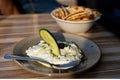 Real authentic photo of fresh Greek Tzatziki yogurt dip and pita bread and pickels in restaurant under golden hour Royalty Free Stock Photo