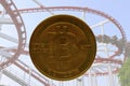 Real bitcoin with roller coaster in background