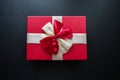 Real box with white and red bow and ribbon top view on holiday isolated on black background. Flat lay. Copy space Royalty Free Stock Photo