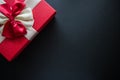 Real box with white and red bow and ribbon top view on holiday isolated on black background. Flat lay. Copy space Royalty Free Stock Photo